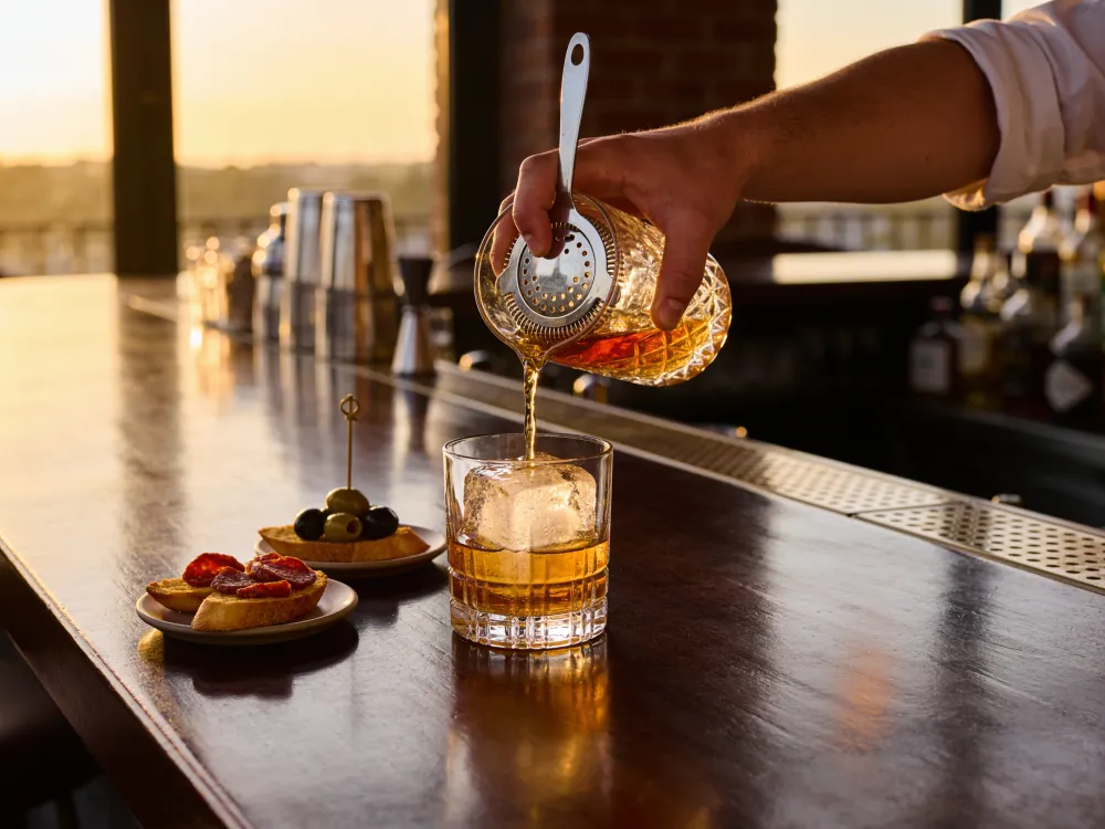 Un cocktail ambrato versato al bancone